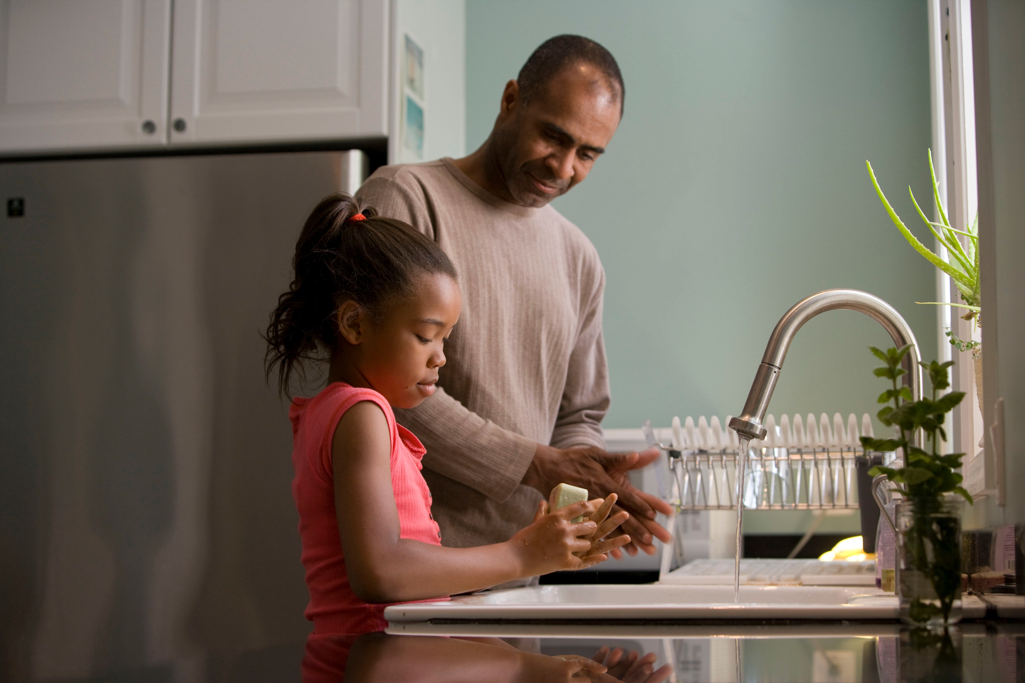 A man and girl washing hands.